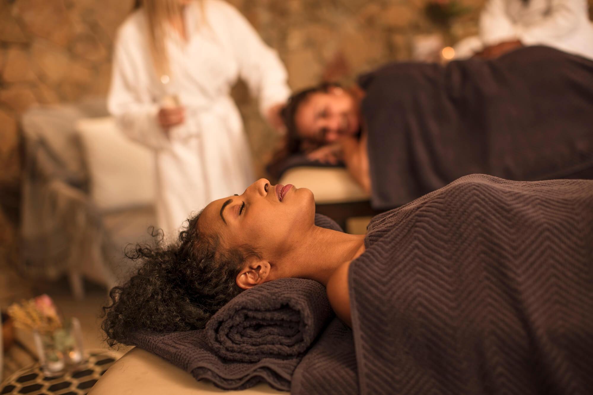 Serviettes roulées et pochon de massage dans une ambiance spa